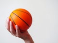 Mini basketball in a hand on a bright background