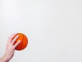 Mini basketball in a hand on a bright background. Copy space