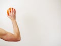 Mini basketball in a muscular hand ready to throw, Copy space, light background