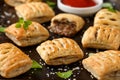 Mini beef patties with vegetables and red wine wrapped in puff pastry