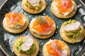 Mini blini pancakes with soft cheese, cold smoked salmon and guacamole Royalty Free Stock Photo