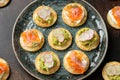 Mini blini pancakes with soft cheese, cold smoked salmon and guacamole Royalty Free Stock Photo