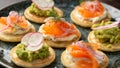 Mini blini pancakes with soft cheese, cold smoked salmon and guacamole Royalty Free Stock Photo