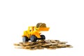 Mini bulldozer truck loading stack coin with pile of gold coin, Royalty Free Stock Photo