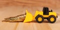 Mini bulldozer truck loading stack coin with pile of gold coin. Royalty Free Stock Photo
