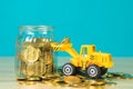 Mini bulldozer truck loading stack coin with pile of gold coin t