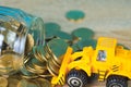 Mini bulldozer truck loading stack coin with pile of gold coin t Royalty Free Stock Photo