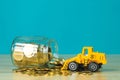 Mini bulldozer truck loading stack coin with pile of gold coin t Royalty Free Stock Photo