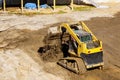 Mini bulldozer working with earth soil while doing landscaping works on construction Royalty Free Stock Photo