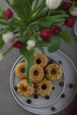 Mini bundt cakes with fruits on plate and bouquet of tulips. Breakfast
