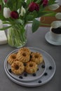 Mini bundt cakes with fruits on plate, cup of coffe and bouquet of tulips. Breakfast Royalty Free Stock Photo