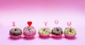 Mini cakes with icing and colorful sprinkles on pink background, text I love you Royalty Free Stock Photo