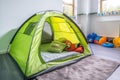 a mini camping tent with sleeping bags in a childs room