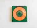Mini CDs stacked on floppy disks, objects isolated on a white background, the evolution of technology