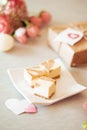 Mini cheese cake platter - caramel cheese cake on white plate with pink peomies and brown paper wrapped present