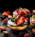 Mini cheesecake covered with chocolate with the addition of fresh berry fruits: blackberry, raspberry, strawberry, cherry and mint Royalty Free Stock Photo