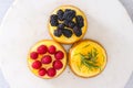 Mini cheesecakes close-up, flat lay. Cheesecake topping ideas. Fresh berries topping, and rosemary and lemon topping Royalty Free Stock Photo