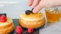 Mini cheesecakes close-up. Topping cheesecakes with orange marmalade, fresh berries, and rosemary Royalty Free Stock Photo