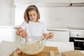 Mini chef girl mixing flour and eggs baking preparing sweet desert smiling happy