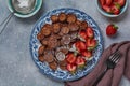 Mini chocolate pancake cereal with strawberries for breakfast on gray concrete table. Trendy home breakfast with tiny pancakes Royalty Free Stock Photo