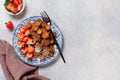 Mini chocolate pancake cereal with strawberries for breakfast on gray concrete table. Trendy home breakfast with tiny pancakes. Royalty Free Stock Photo