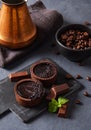 Mini chocolate tarts with coffee beans on a dark background. Close up