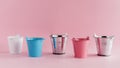 Mini colored tin pails or buckets on pink background