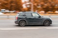 Mini Cooper on the city road. Fast moving car on Moscow streets. Vehicle driving along the street in city with blurred autumn