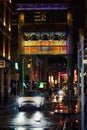 Mini Cooper hatchback car driving through Chinatown at night