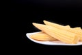 Mini Corn cob preserved on plate on wooden board. Royalty Free Stock Photo