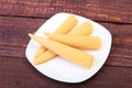 Mini Corn cob preserved on plate on wooden board. Royalty Free Stock Photo