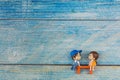 Mini cute doll of Couple little boy and little girl About to kiss on a blue wood background , social distance concept