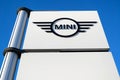 Mini dealership sign against blue sky.