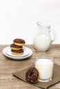 Mini donuts covered with chocolate glaze served with bottle, jug, glass of milk. Stack of tasty sweet sugar creamy or