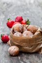 Mini doughnuts stuffed with strawberry jam in paper bag on rust