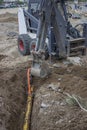 Mini excavator digging up a electrical cables from trench