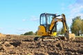 Mini excavator JCB 8025 ZTS digging earth in a field or forest