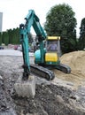 Mini excavator works on road repair