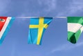 Mini fabric rail flag of Sweden it is consists of a yellow or gold Nordic Cross on a field of blue, hanging on the rope cloth. Royalty Free Stock Photo