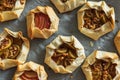Mini Fig and Apple Galettes with Nuts on Parchment Background Royalty Free Stock Photo
