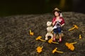 Mini figure of girl with her dog enjoying tea while reading a book Royalty Free Stock Photo