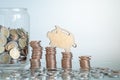 Mini figure piggy bank climbing on stacks of coin Royalty Free Stock Photo