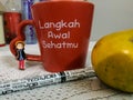 Mini figure standing in front of mug,pen and fruit Royalty Free Stock Photo