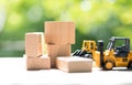 Mini forklift truck load wooden block to complete building with natural green background