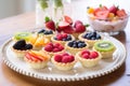 mini fruit tarts arranged on a pastel pink tray