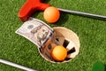 Mini Golf club, ball and money on the artificial grass Royalty Free Stock Photo