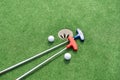 Mini-golf clubs and balls of different colors laid on artificial grass Royalty Free Stock Photo