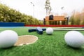 Mini-golf clubs and balls of different colors laid on artificial grass Royalty Free Stock Photo