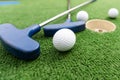 Mini-golf clubs and balls of different colors laid on artificial grass Royalty Free Stock Photo