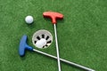 Mini-golf clubs and balls of different colors laid on artificial grass Royalty Free Stock Photo